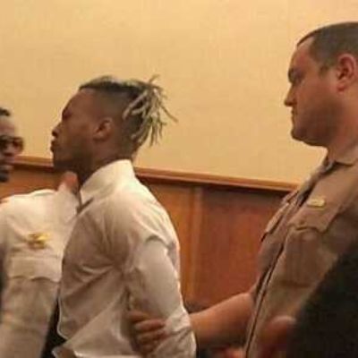 The police is grabbing his hands in the picture.